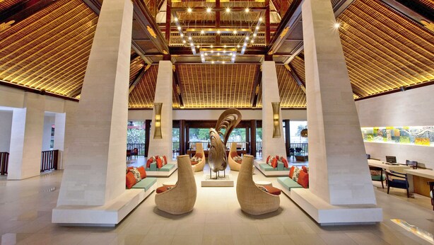 A spacious lobby with high ceilings, large columns, and a central seating area with sofas and chairs. - Holiday Inn Resort Baruna Bali by IHG (Kuta)