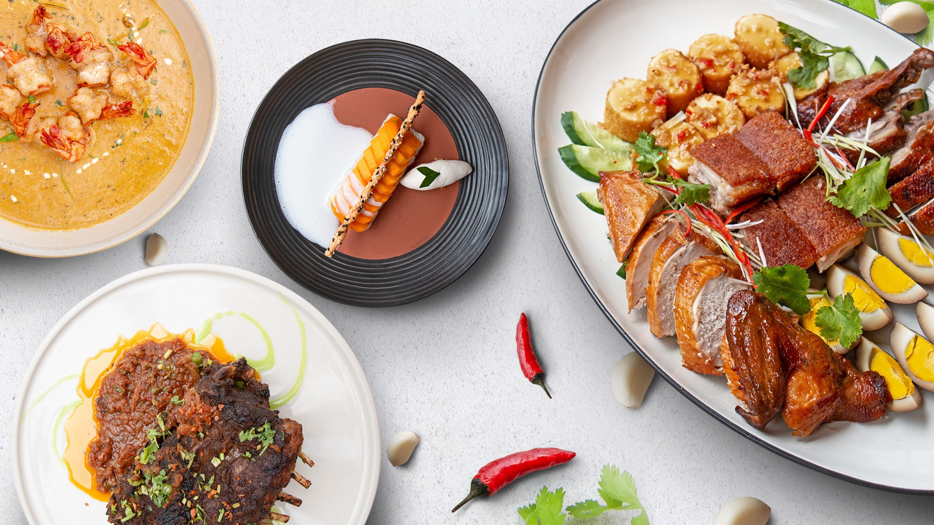 A variety of dishes including a plate with sliced meat, a bowl of soup, and a plate with a dessert.