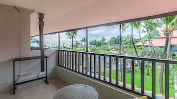 A balcony with a view of a landscaped garden and palm trees.