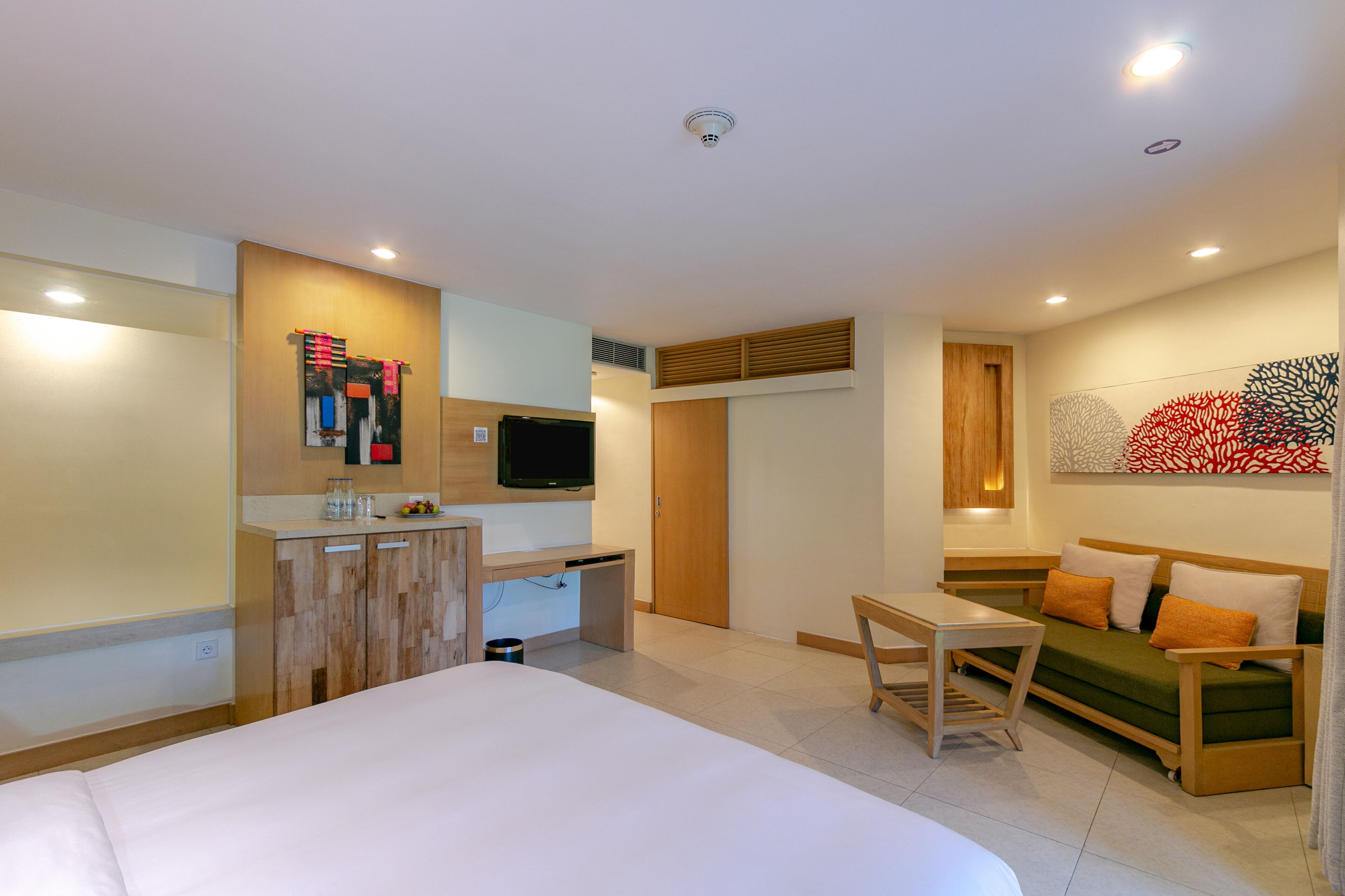 Suite, varias camas, vista al jardín | Edredón, minibar, caja de seguridad en la habitación y escritorio 