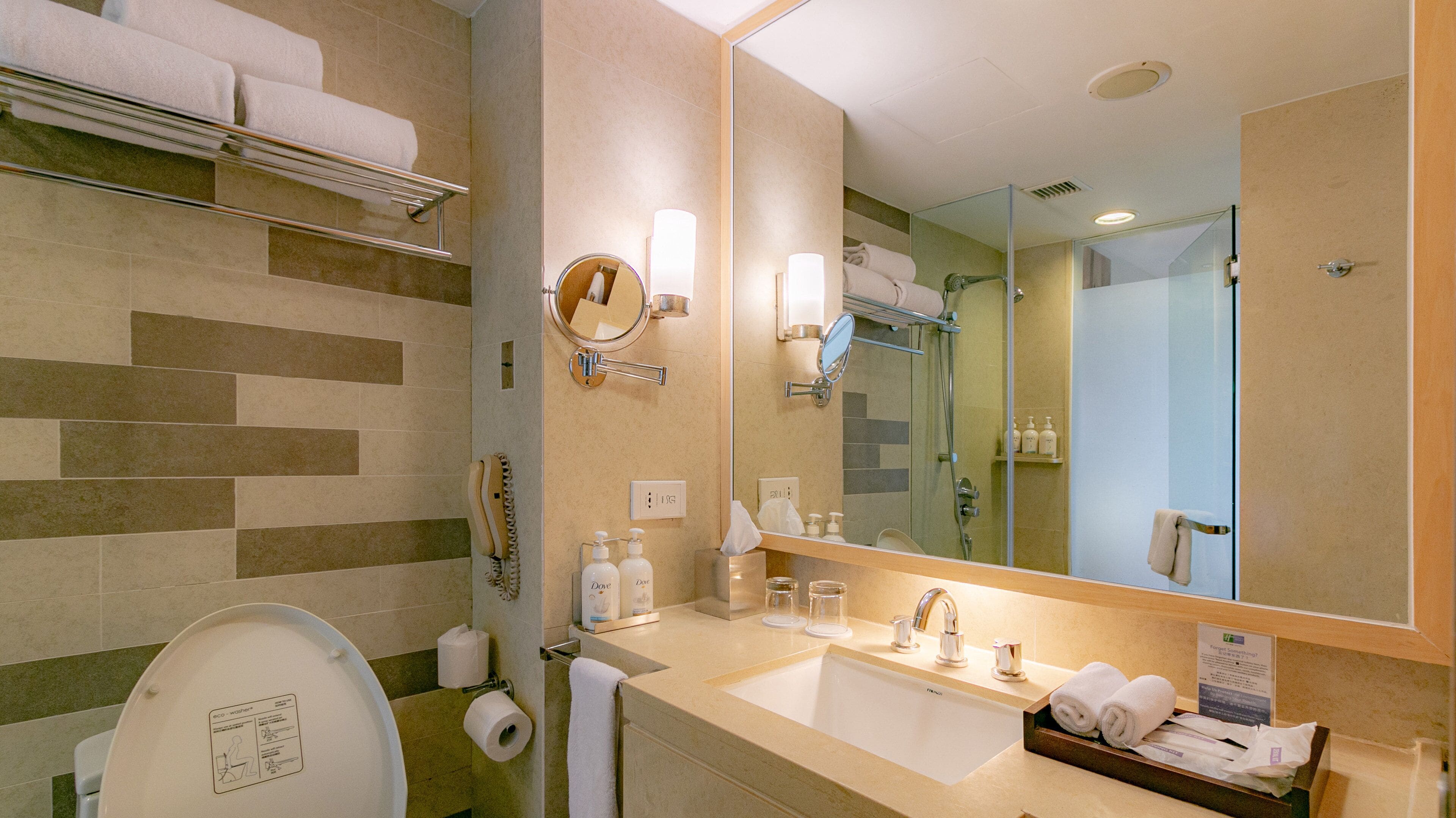 A modern bathroom with a toilet, sink, and shower.