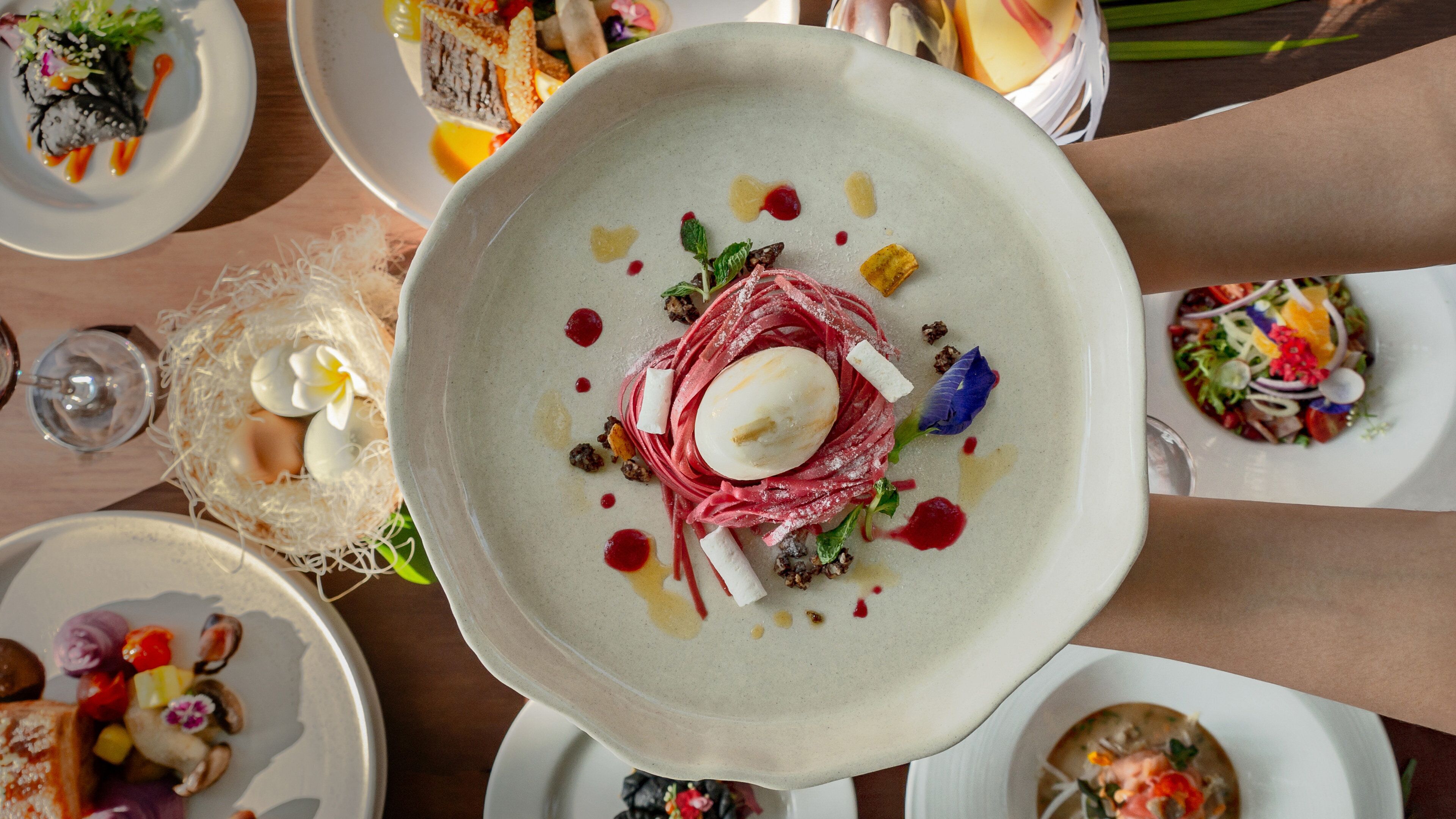Una mesa de comedor con varios platos de comida, cada uno con una presentación distinta.