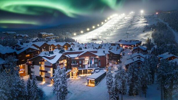 A snow-covered ski resort at night with illuminated buildings and a ski lift in operation. - Break Sokos Hotel Levi (Kittila)
