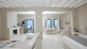 Una habitación de hotel moderna con balcón, comedor y cama.