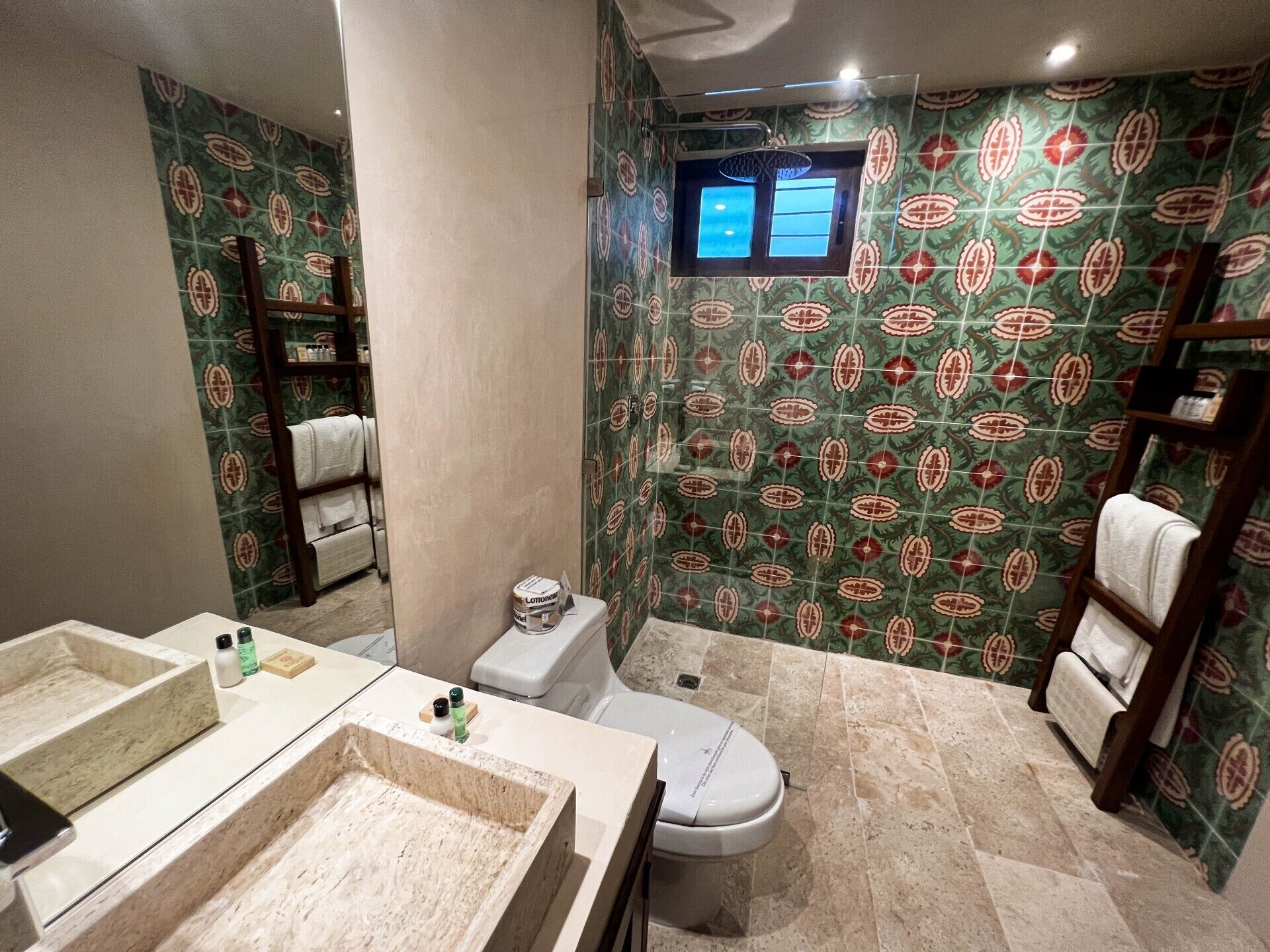 Een badkamer met toilet, een wastafel met een marmeren kom en een douchehoek.