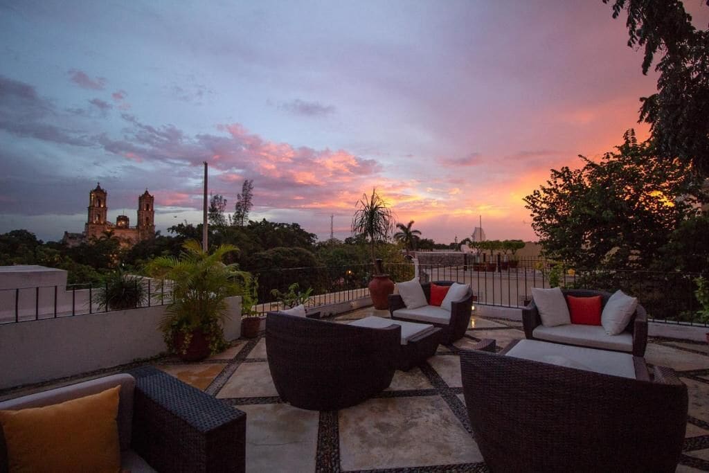 A rooftop patio with outdoor furniture and a view of a historic building in the background.