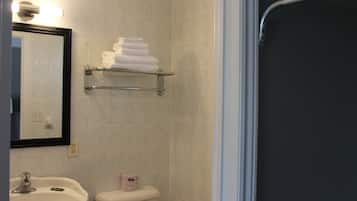 A bathroom with a sink, toilet, and a towel rack with folded towels.