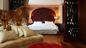 Un dormitorio con una cama grande, un sofá y un cabecero decorativo.