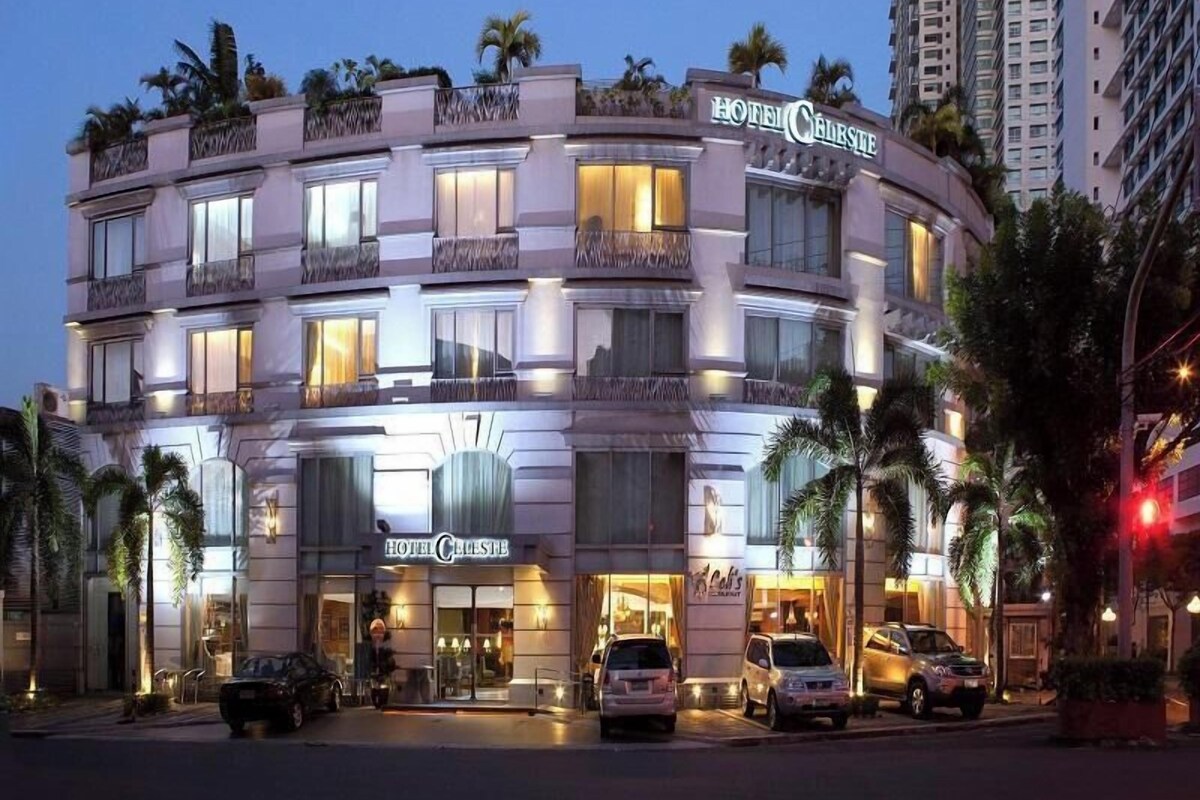 Un hotel de varios pisos con balcones, un restaurante y un estacionamiento.