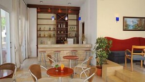 A hotel lobby with a bar area, seating arrangements, and a painting on the wall. - Petrosana Hotel Apartments (Ayia Napa)