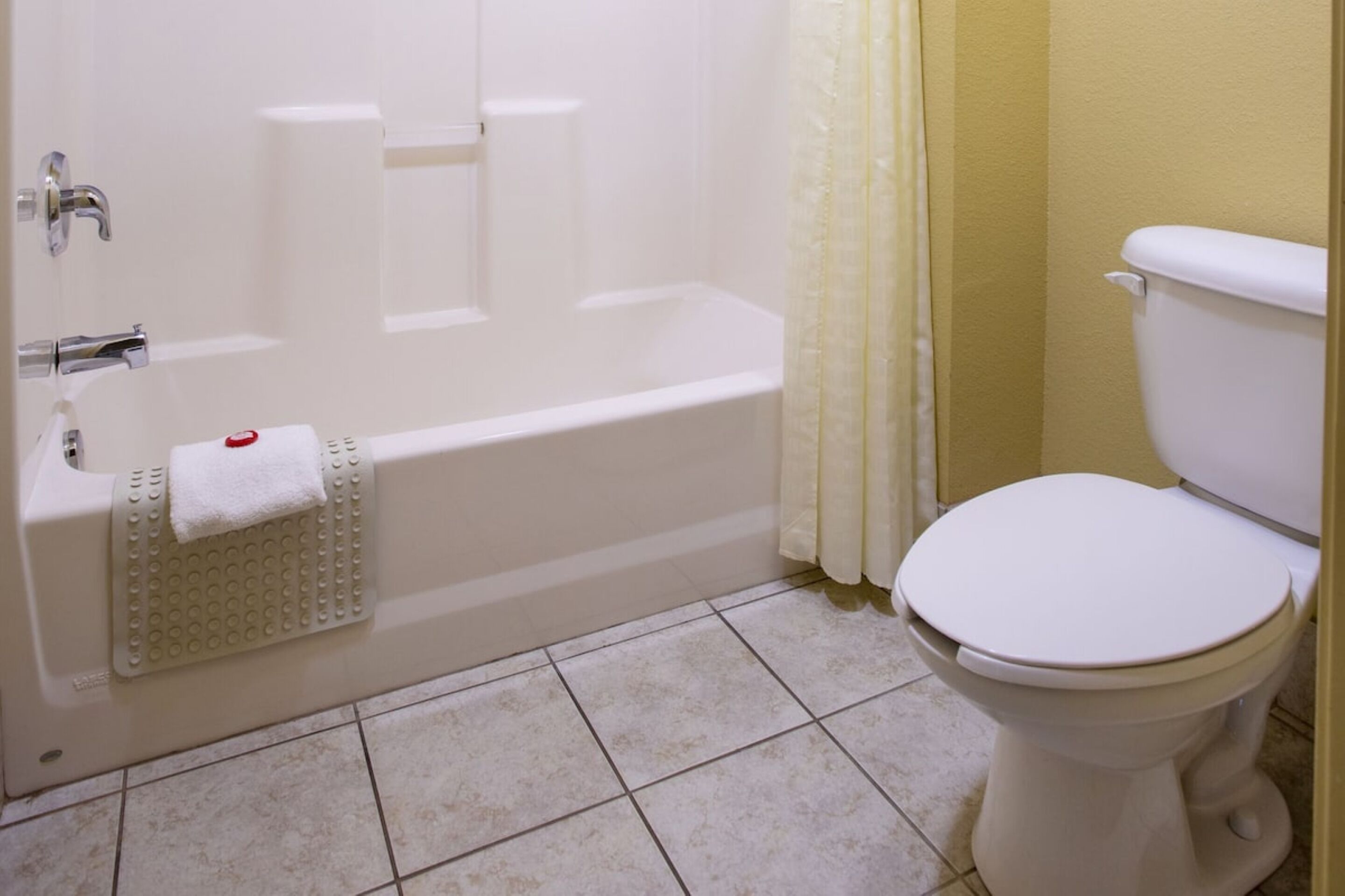 A bathroom with a bathtub, toilet, and a shower area.