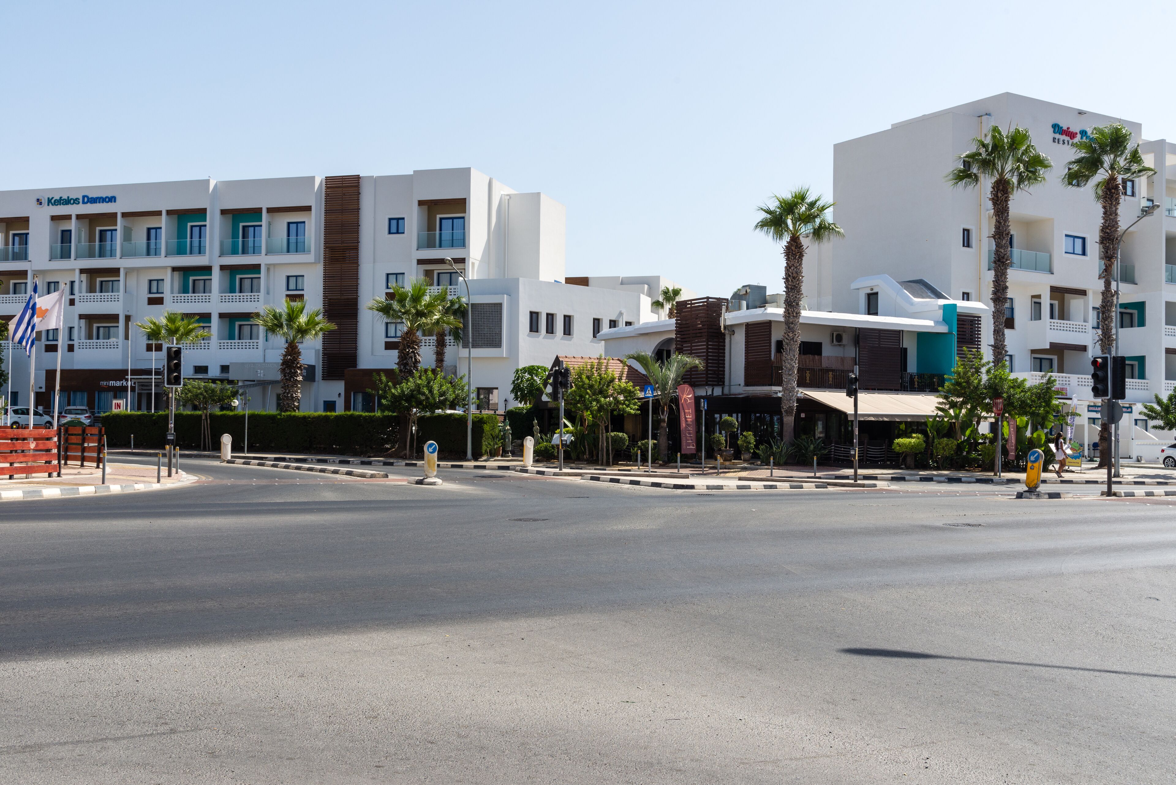 A hotel with multiple floors, balconies, and palm trees.
