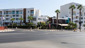 Un hotel con diversi piani, balconi e palme.