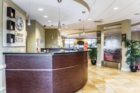 A reception area with a marble reception desk, pendant lighting, and potted plants.. Comfort Suites Palm Bay - Melbourne