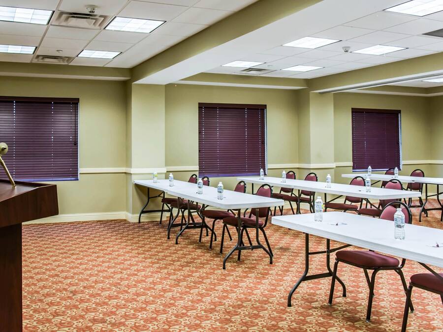 A conference room with tables, chairs, and a podium.