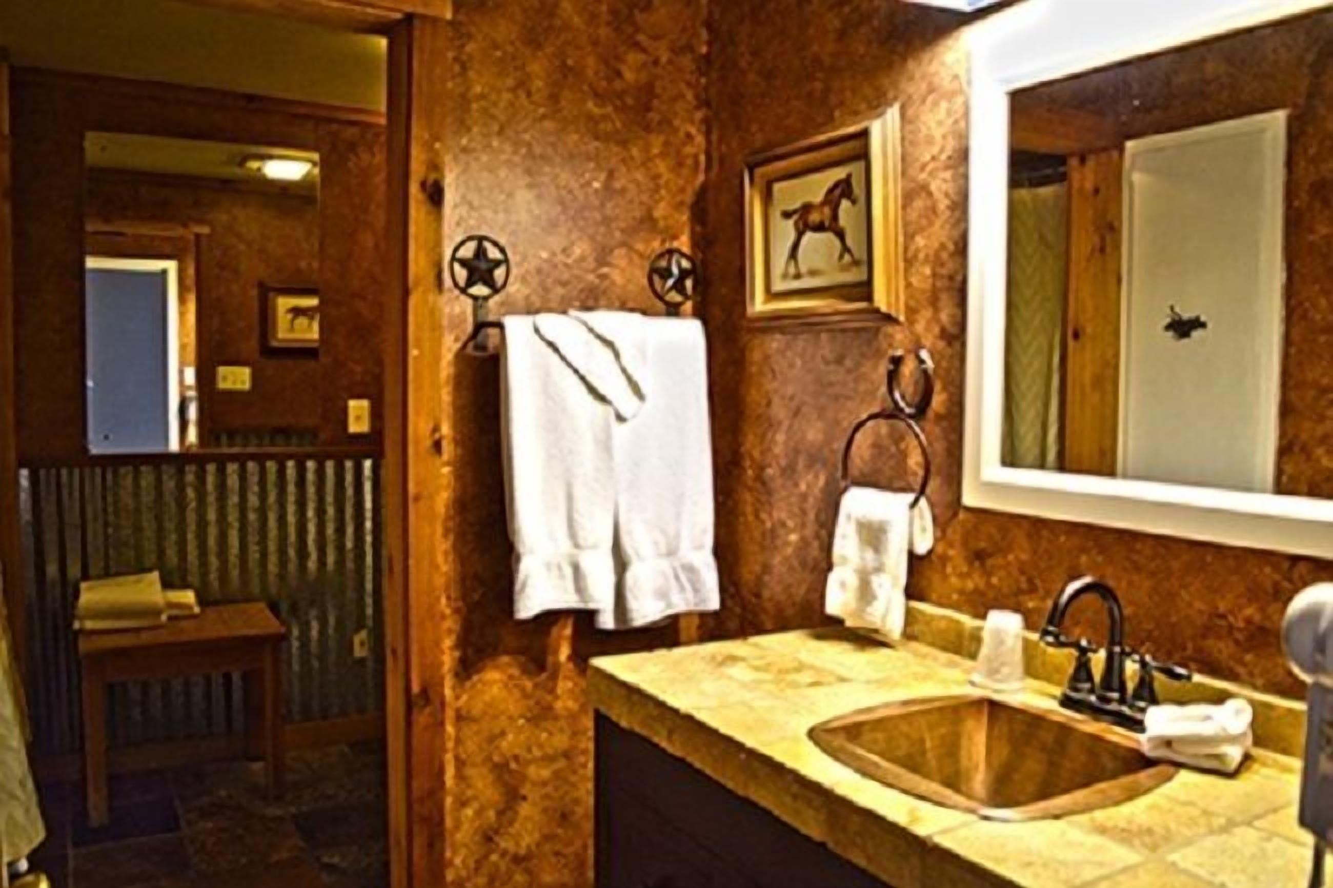 A bathroom with a wooden sink, a mirror, and a towel hanging on a rack.