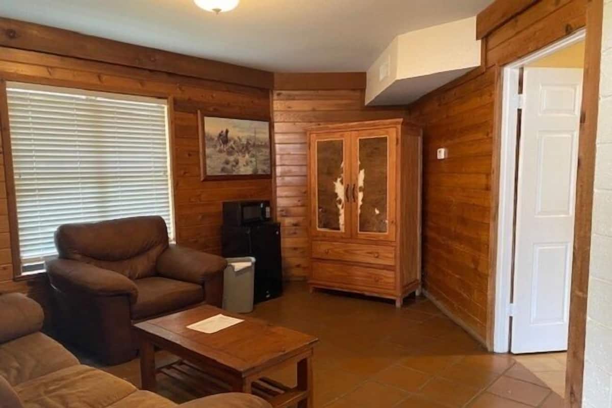 Un interior de madera con un sofá, un mueble aparador y un televisor.