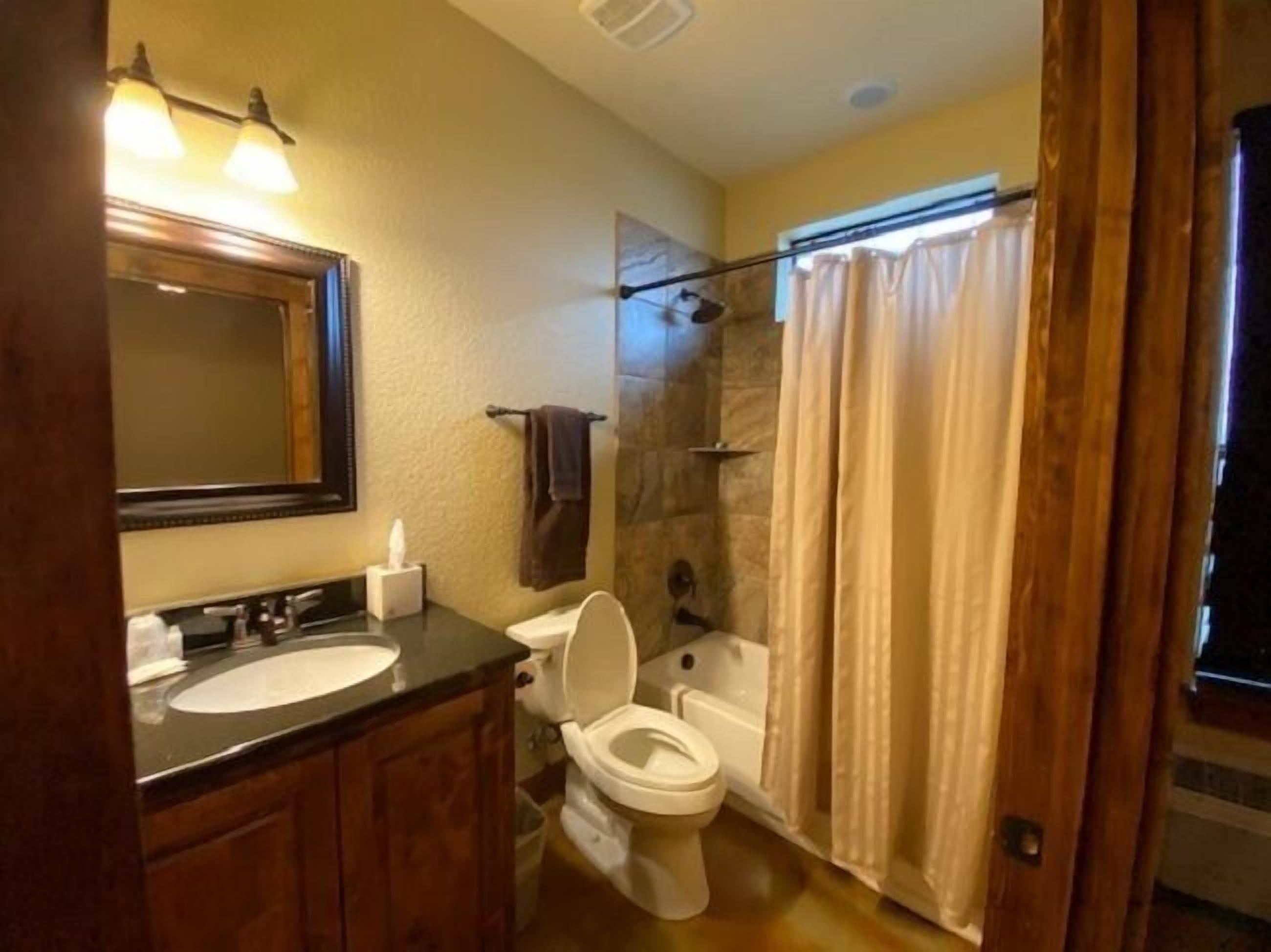 Een badkamer met een wastafel, toilet en douche.