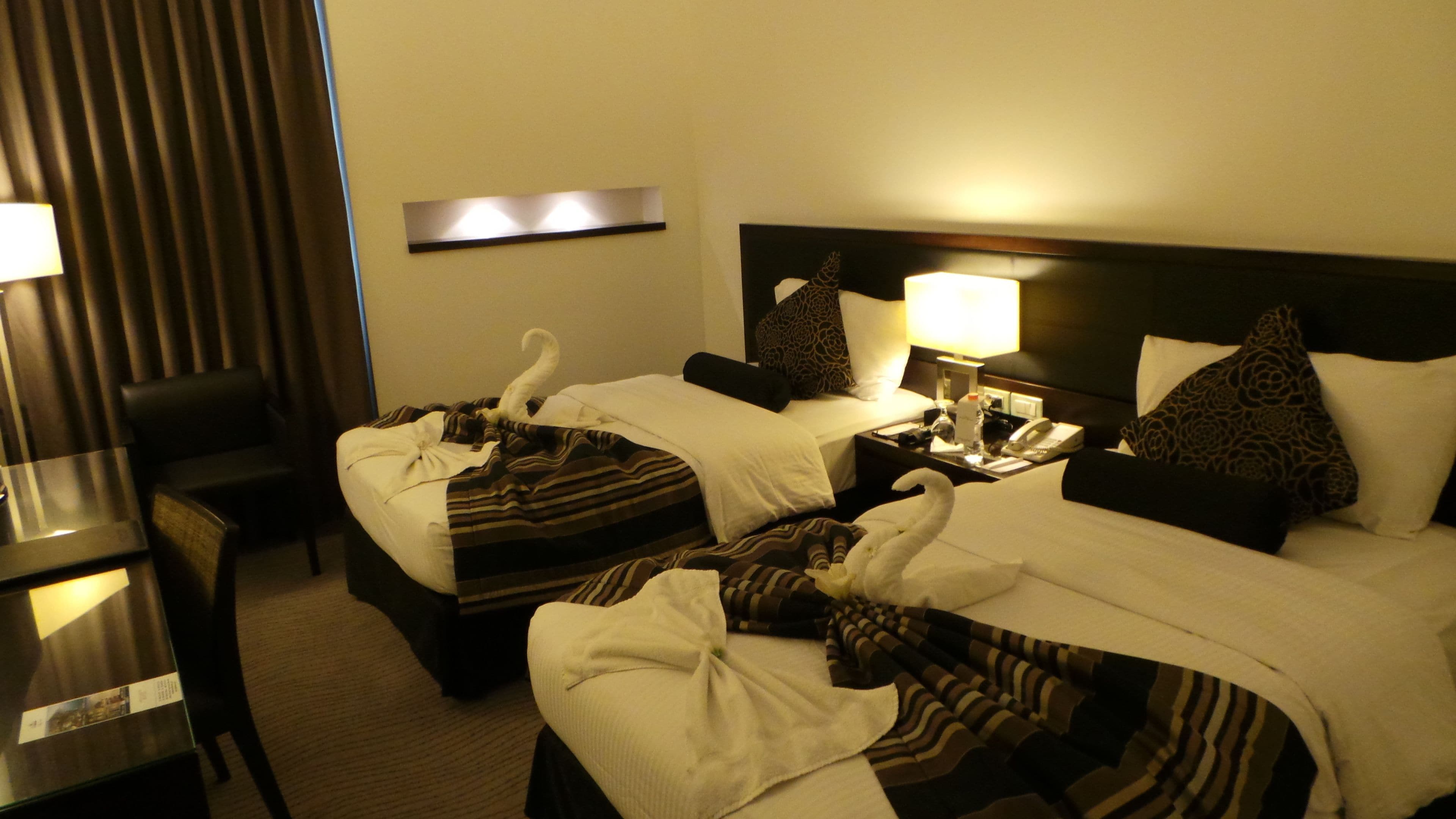 Une chambre d’hôtel avec deux lits, un bureau et une chaise.