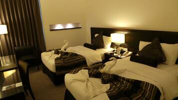 Une chambre d’hôtel avec deux lits, un bureau et une chaise.