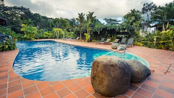 Una piscina al aire libre, sillones reclinables de piscina