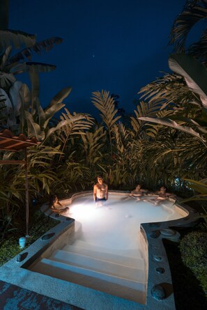 A hot tub surrounded by tropical plants at night. - Casa Luna Hotel & Spa (La Fortuna)