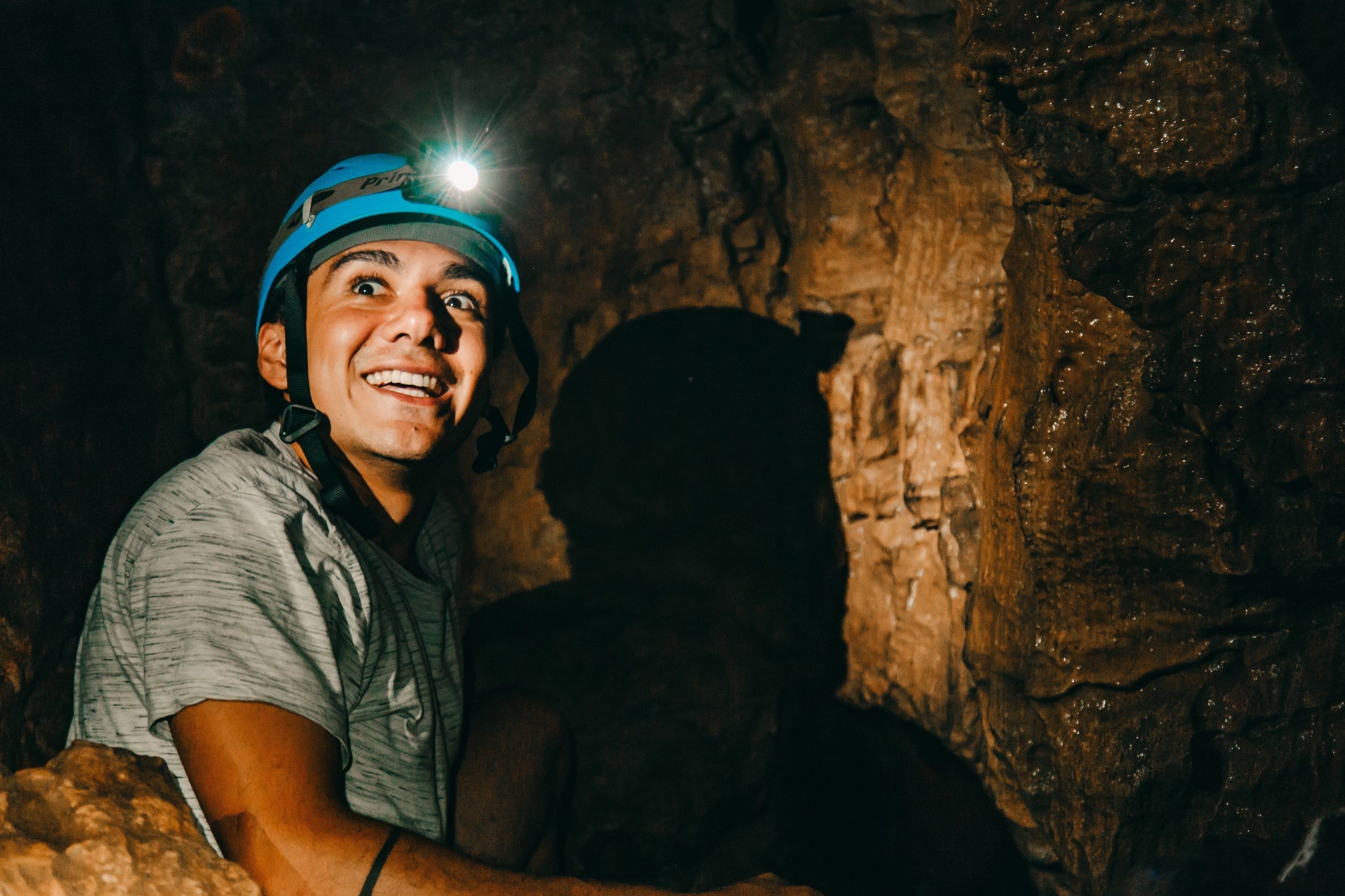 Uma pessoa com capacete dentro de uma caverna com paredes irregulares.