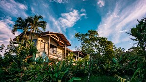 A house surrounded by lush greenery and a clear blue sky. - Casa Luna Hotel & Spa (La Fortuna)