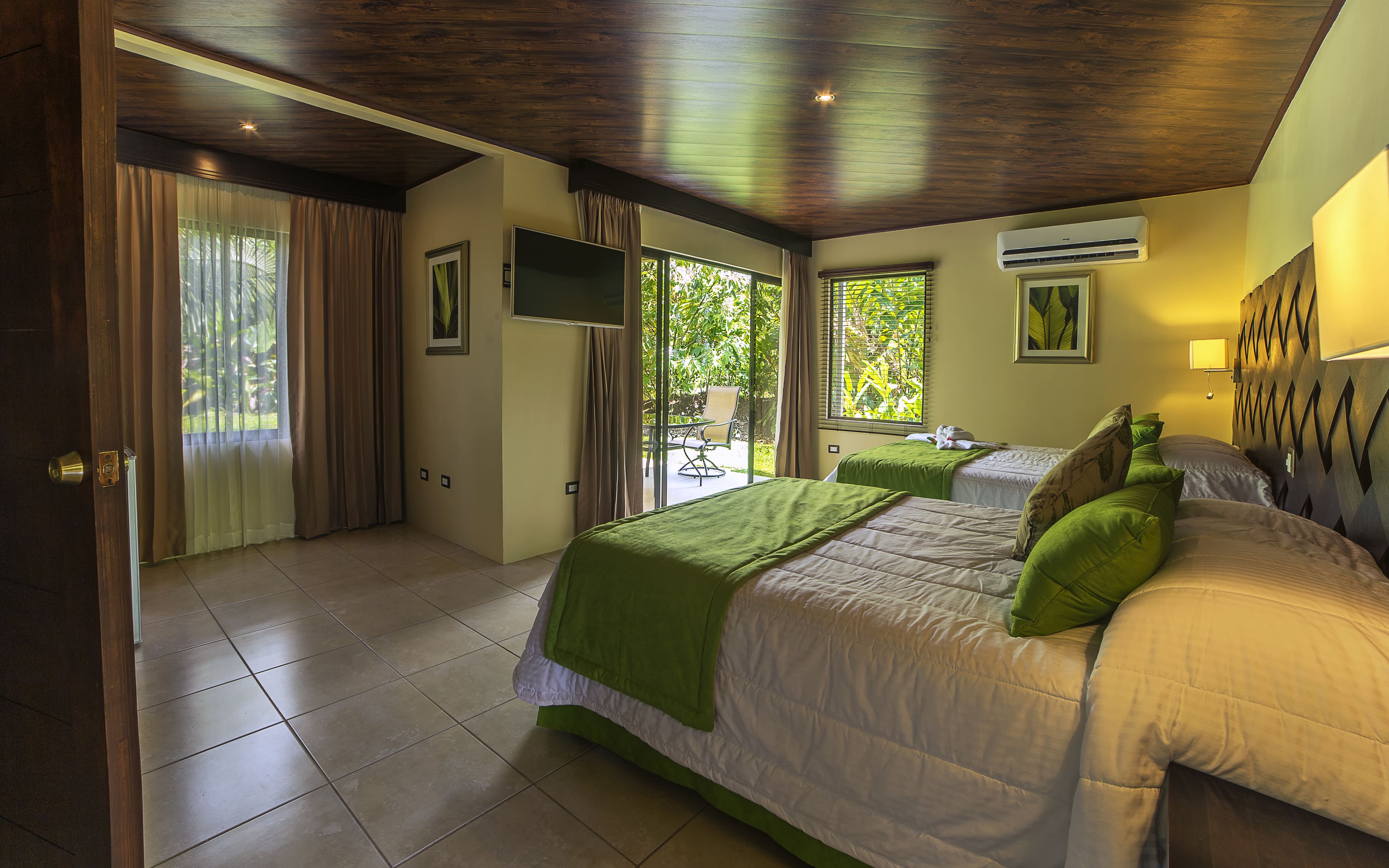 Un dormitorio con una cama, un televisor y una ventana.