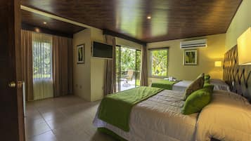 A bedroom with a bed, a TV, and a window.
