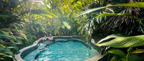 Un bain à remous entouré d’une végétation tropicale luxuriante.