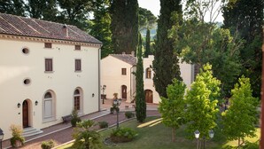 A courtyard with a building featuring arched windows and a tiled roof.