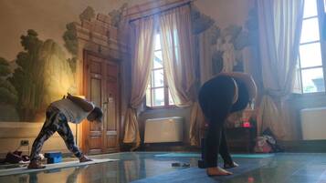 Une pièce avec un grand miroir, une porte en bois et une statue.