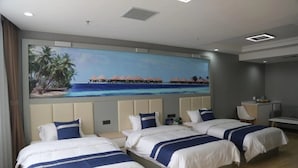 A hotel room with three beds, a painting of a beach scene, and a desk with a chair. - Grand Golden Phoenix (Beijing)