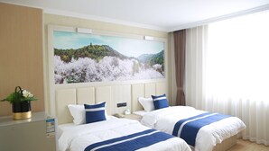 A hotel room with two beds, a large landscape painting, a desk, and a plant. - Grand Golden Phoenix (Beijing)