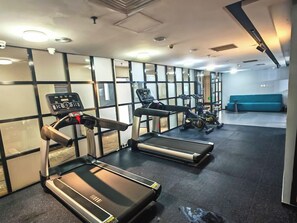 A gym with treadmills, a stationary bike, and a rowing machine. - Grand Golden Phoenix (Beijing)