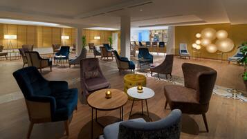 A spacious lobby with multiple seating areas, a bar, and a reception desk.