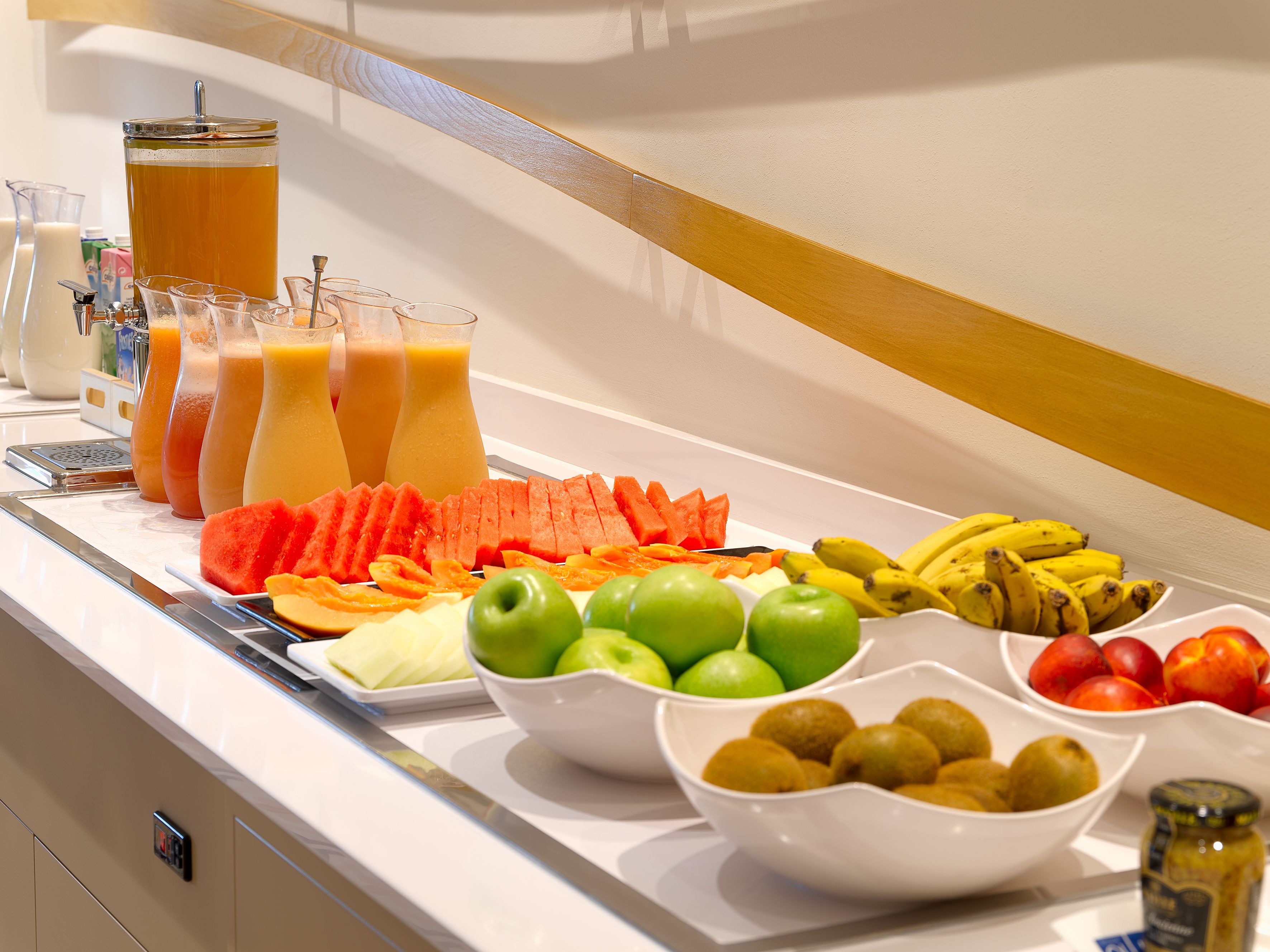 Un bufé con diversas frutas, verduras y zumos.
