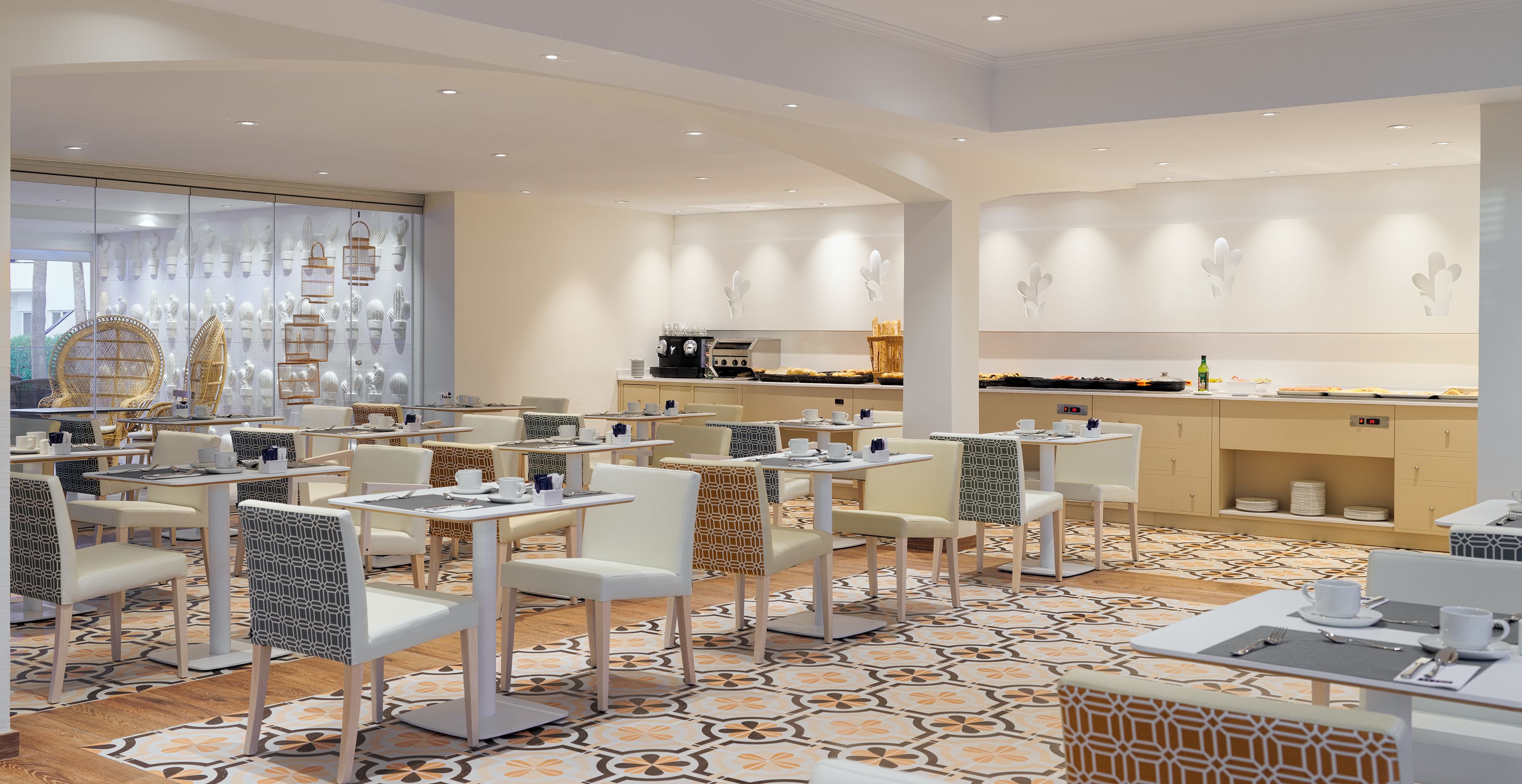 Un restaurante moderno con mobiliario blanco y suelo estampado.