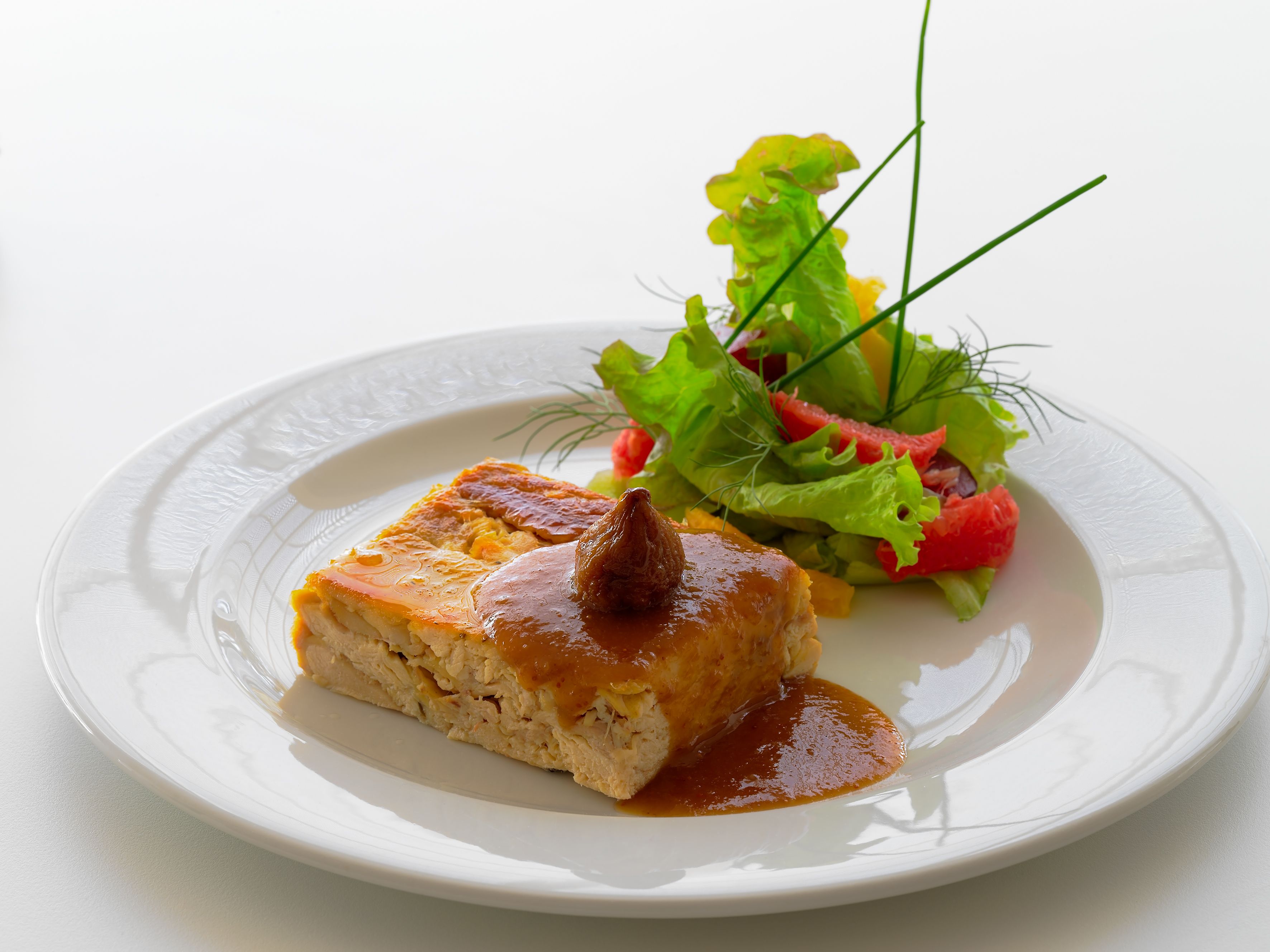 A plate with a piece of food and a side salad.