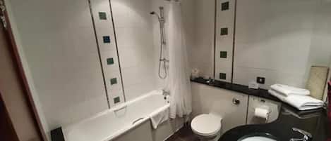 Un baño moderno con bañera, inodoro y lavamanos.
