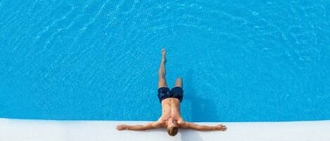 Una persona recostada boca arriba en una piscina.