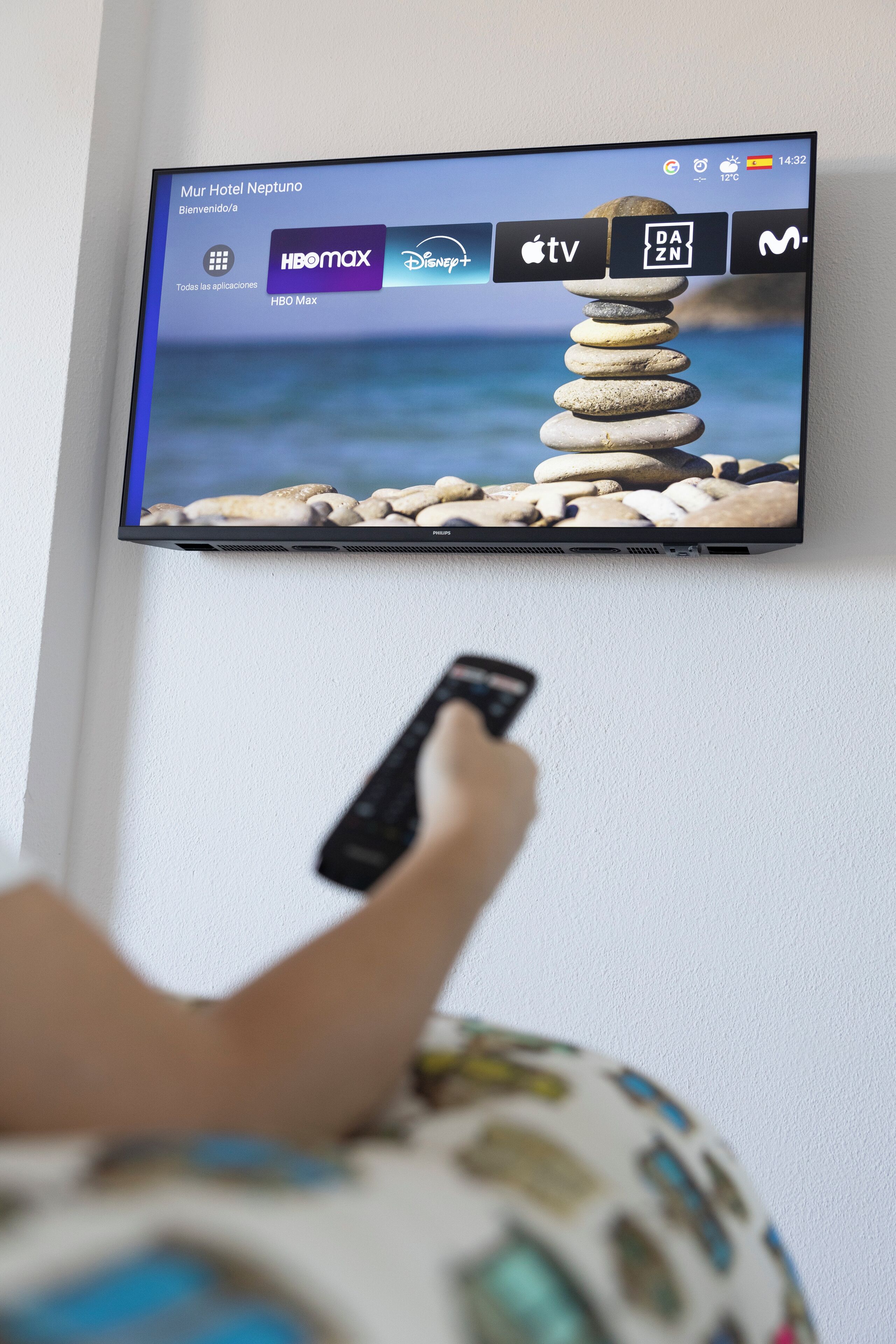 Een televisie waarop een hotel welkomstscherm wordt getoond, met diverse zenderlogo’s, waaronder HBO Max en Disney+.