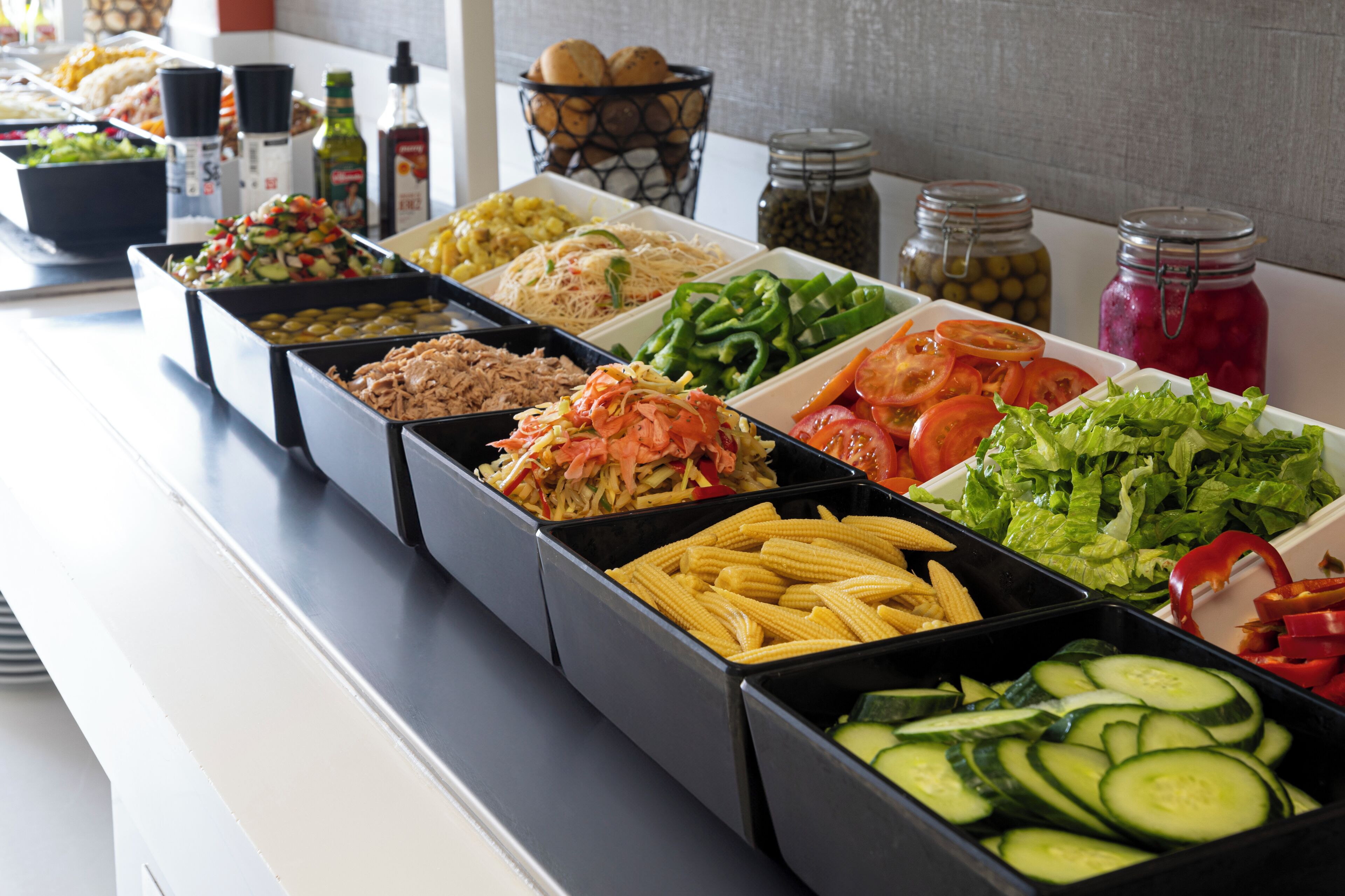 A buffet with various food options including salads, vegetables, and meats.