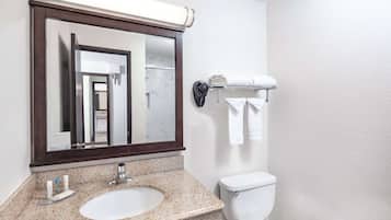 A bathroom with a sink, mirror, towel rack, and toilet.