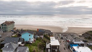 A coastal town with a beach, houses, and a parking area.