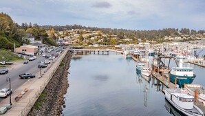 A marina with boats docked, a road with vehicles, and a bridge connecting to a residential area.