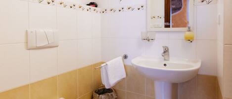 Un baño con inodoro, lavabo y espejo.
