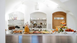 Een buffetopstelling met diverse gerechten en drankjes.