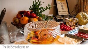 A breakfast buffet with various fruits, cheeses, and spreads.